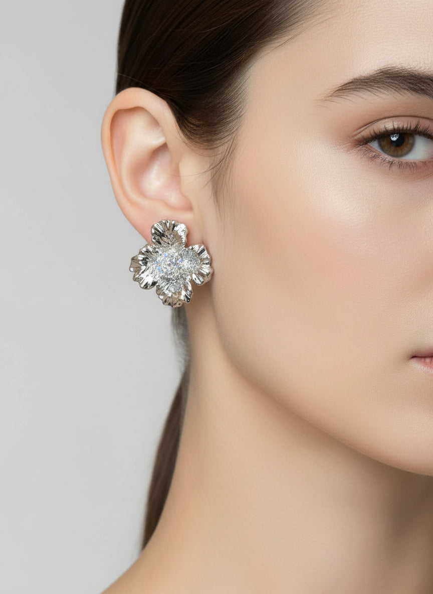 close up of a silver plated floral earring with a zirconia gem centre